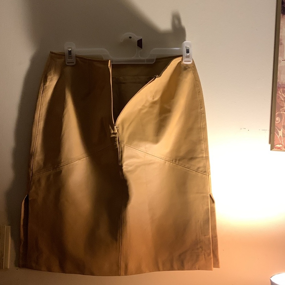 Tan short leather skirt with split on left and right zipper in back